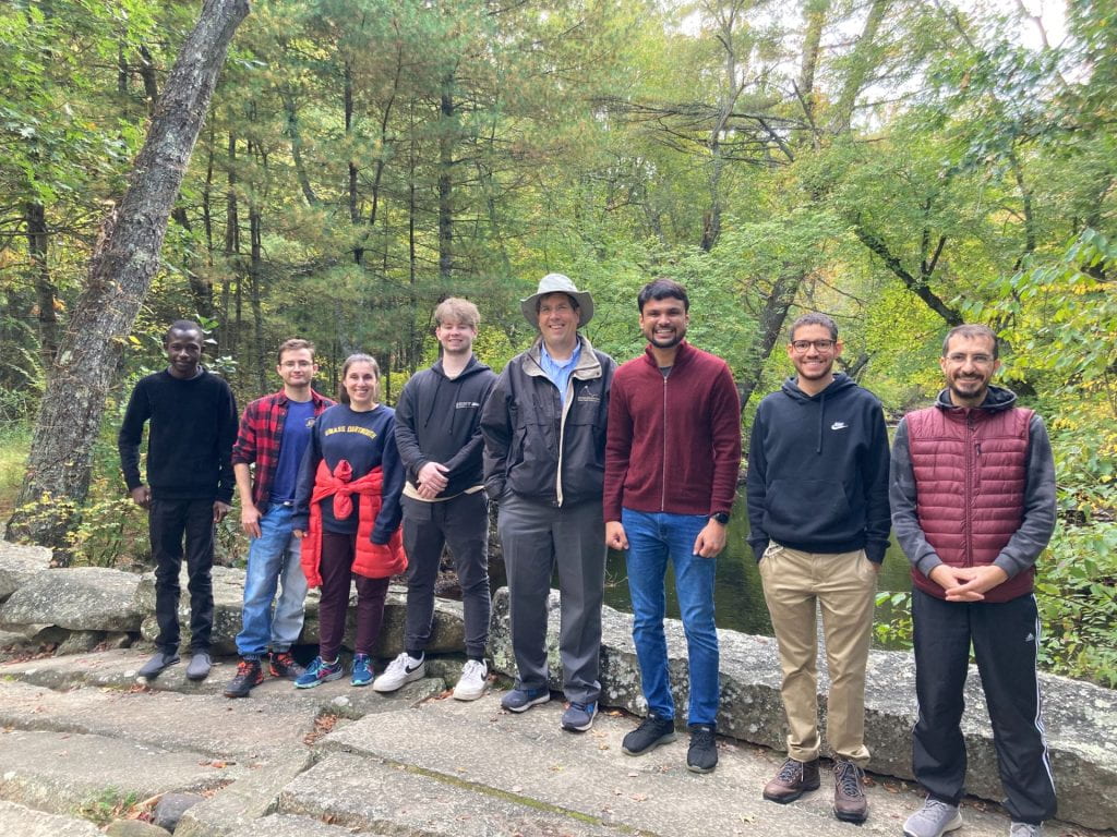Students standing on stone bridge in the woods